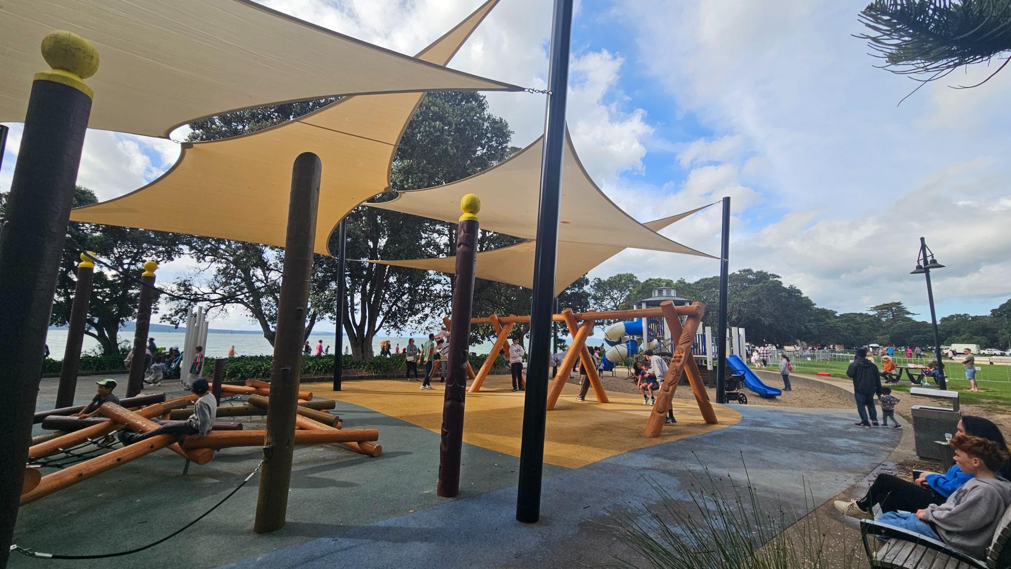 Toddler zone with shade sails, balance equipment, and soft surfacing at Mission Bay
