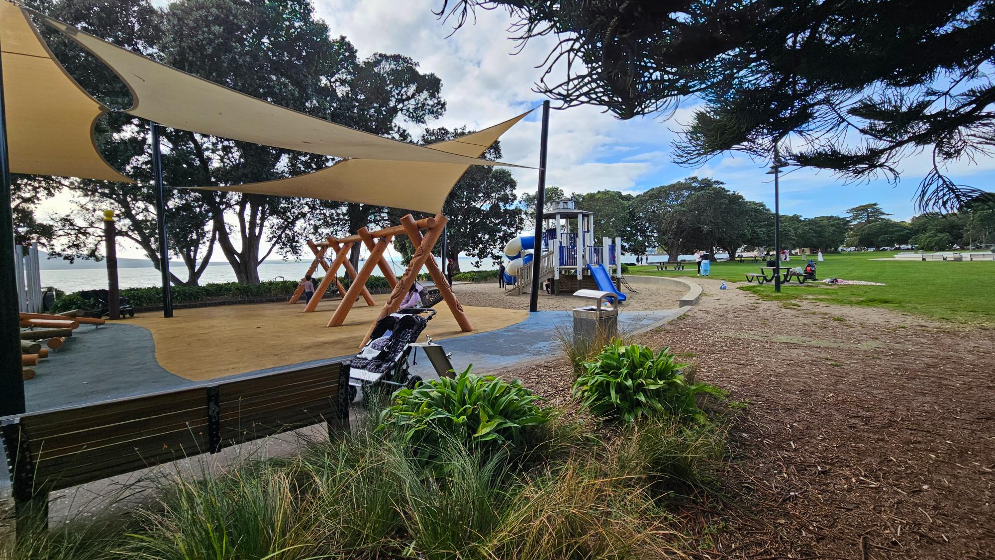 Selwyn Reserve lawn, picnic spots, and beach access beside the play area