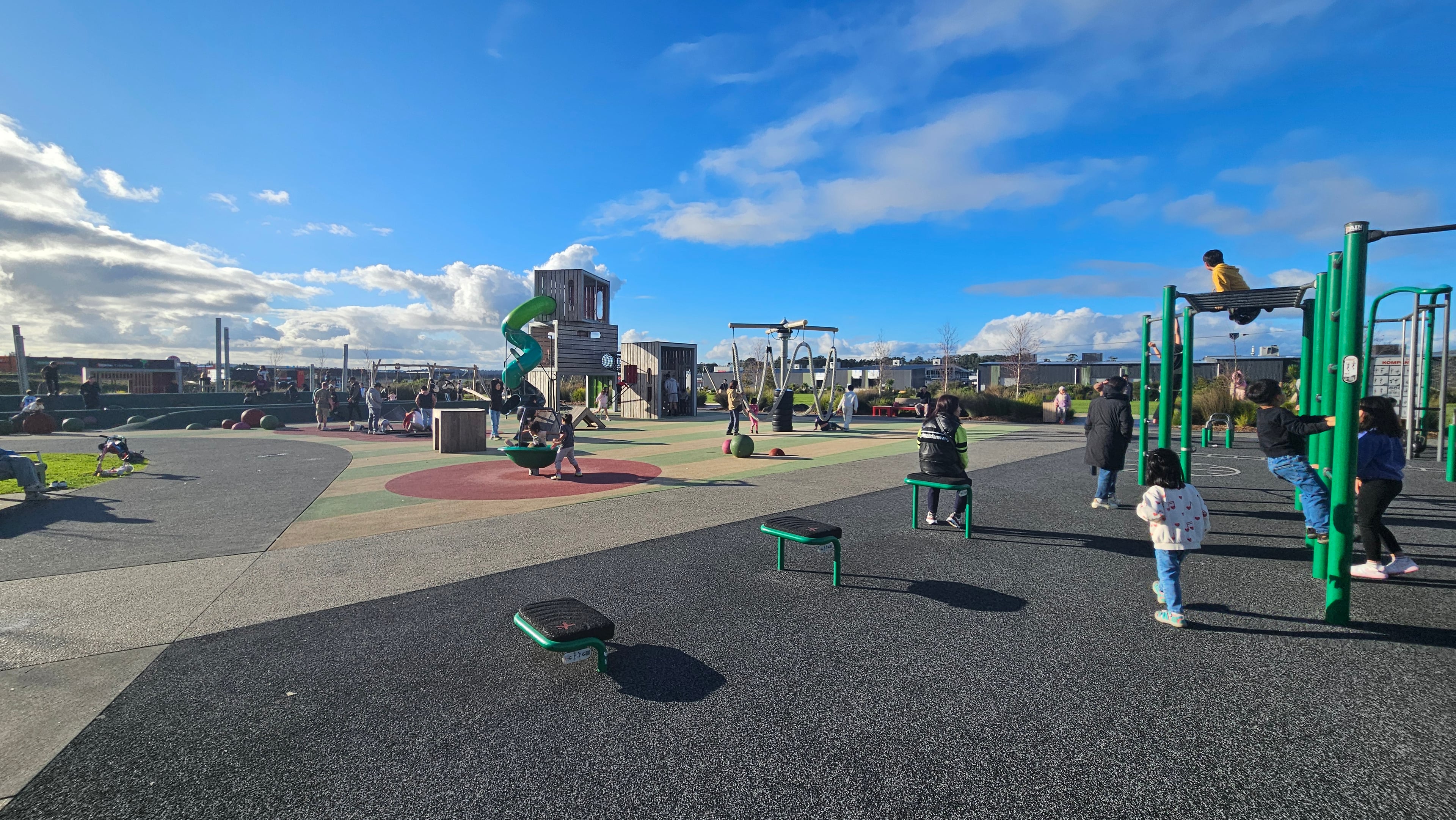Older-kids zone — spinner, slide, and rope ring swings around a central pole