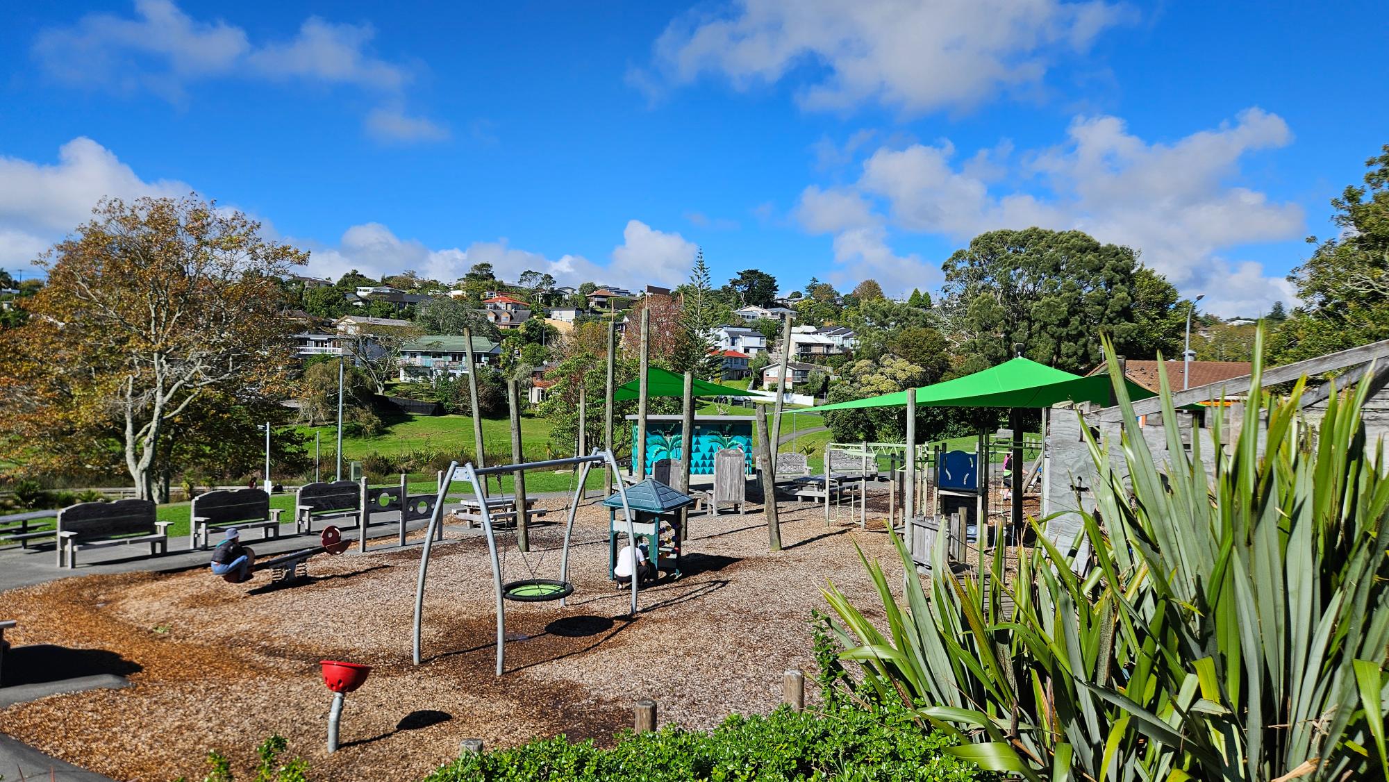 Sherwood Reserve Playground, Browns Bay — shaded play areas, wood chip surfacing, and mixed equipment for different ages