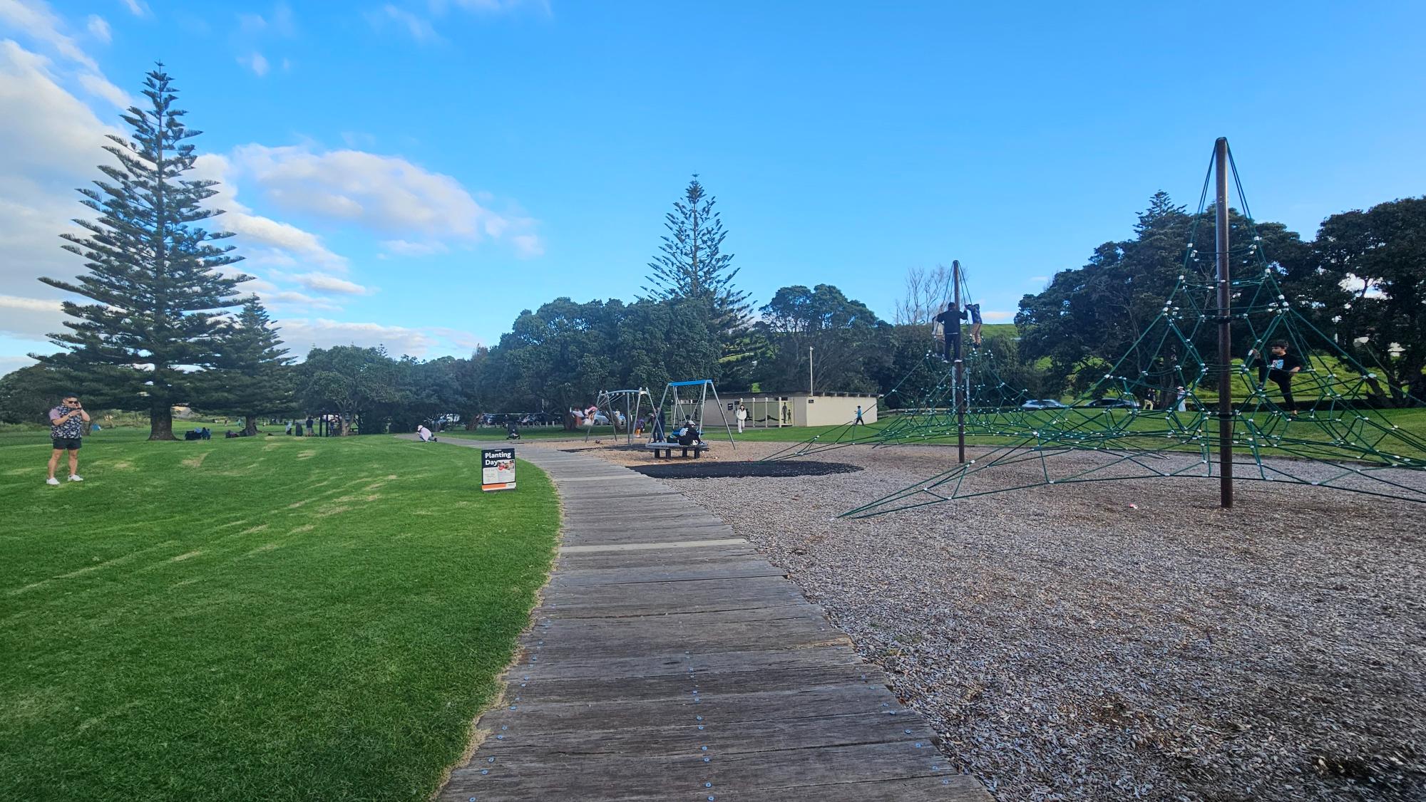 Boardwalk path and coastal park setting near Long Bay Park Playground