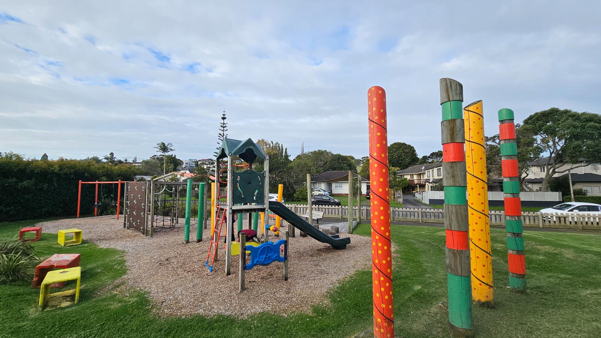 Colourful play structures and bright orange swings at Seine Reserve Playground