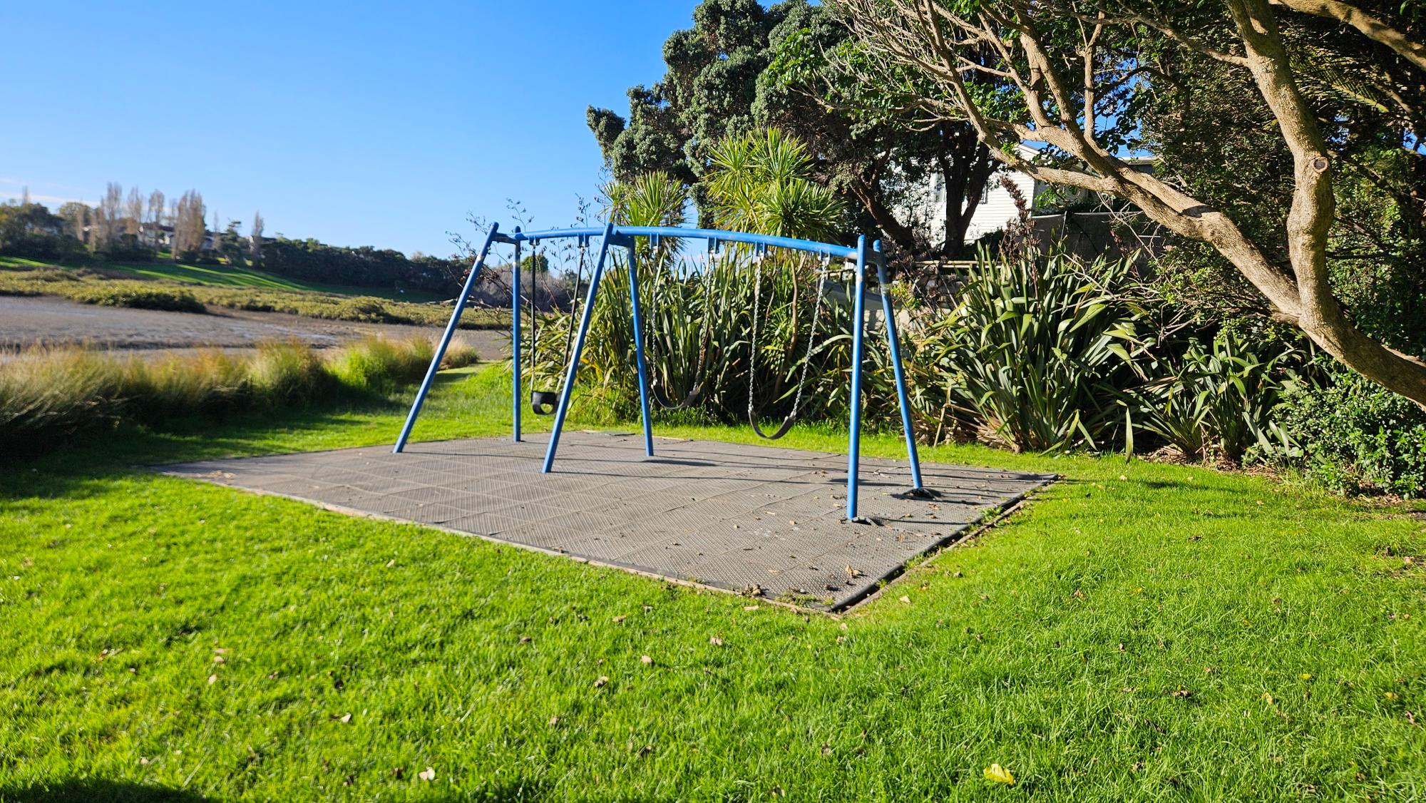 Three swings and picnic table at Holloway Reserve Playground