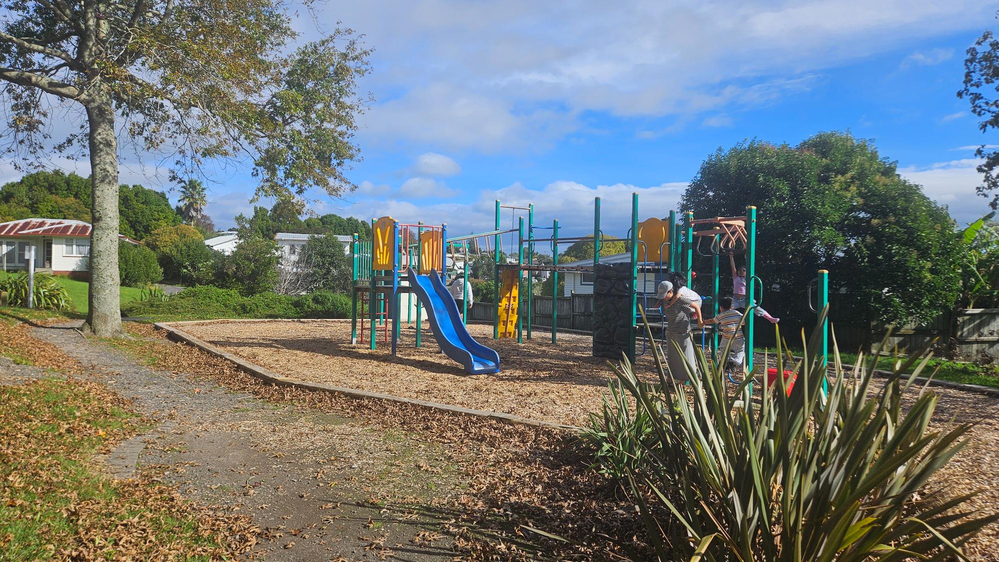 Classic play equipment and wood chip surfacing at Kaipātiki Park Playground, Glenfield