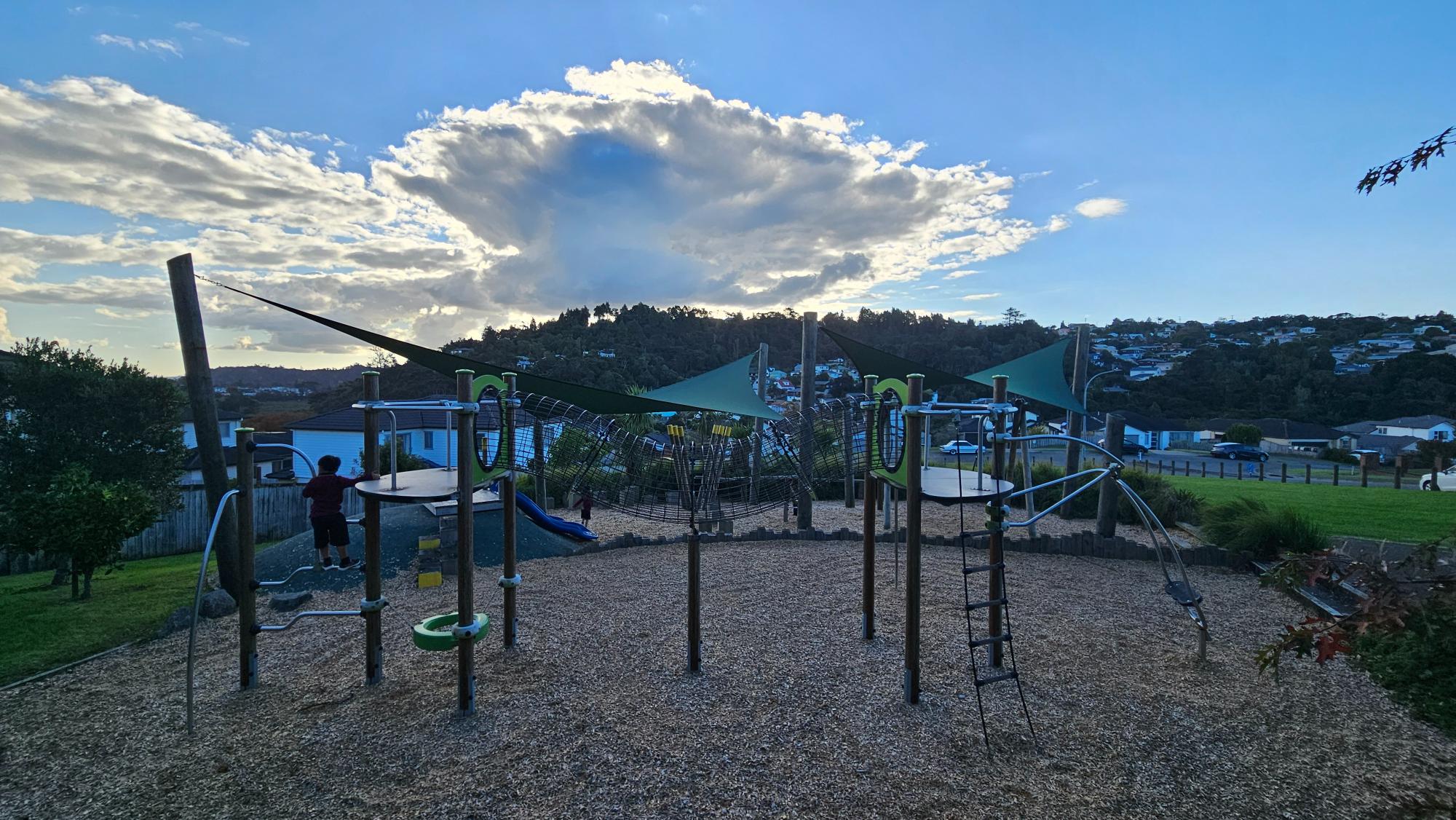 Tamahere Reserve Playground, Glenfield — hilltop outlook over ridgelines and rooftops from Tamahere Drive