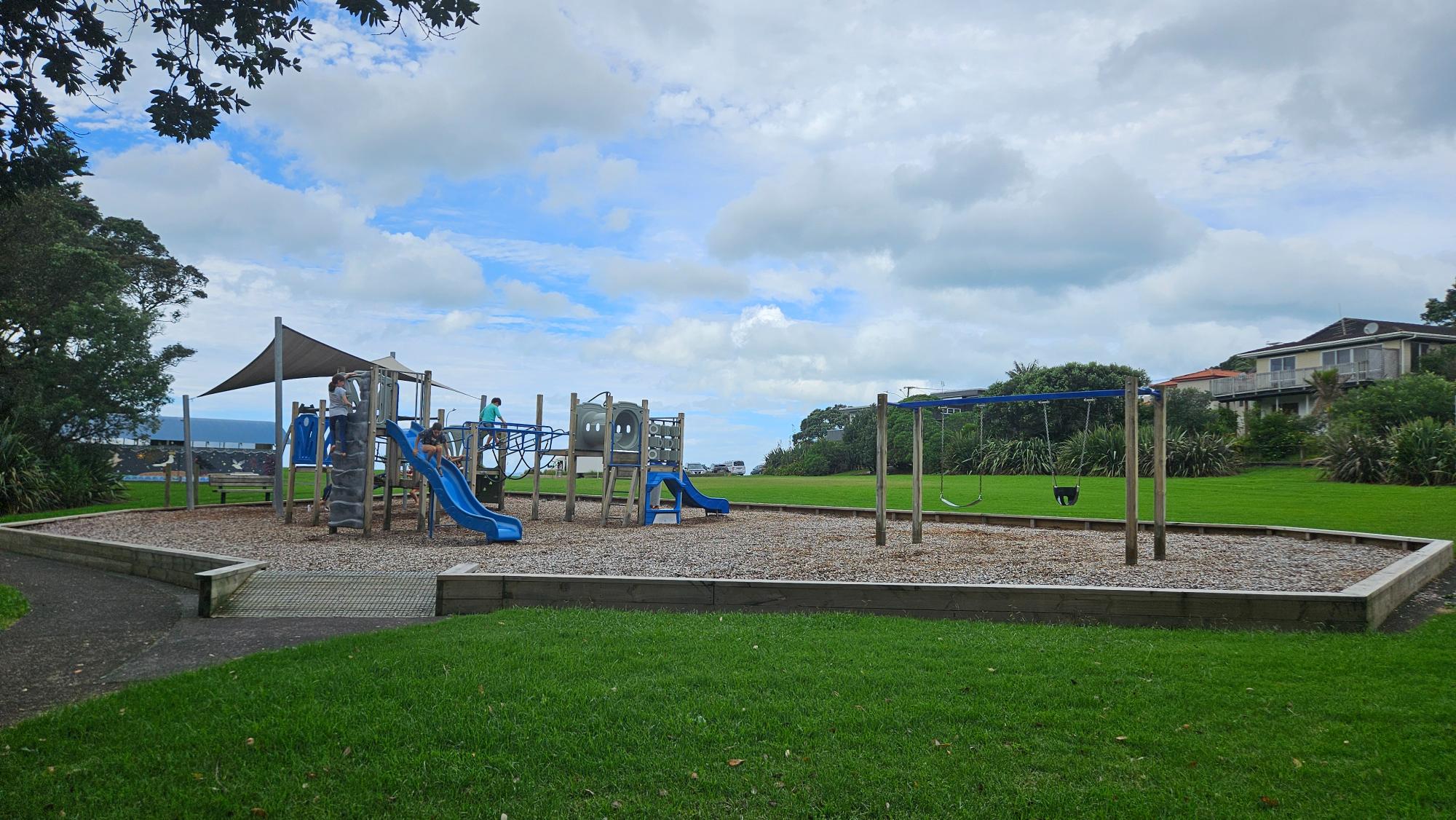 Rothesay Bay Beach Playground with compact toddler equipment and coastal backdrop