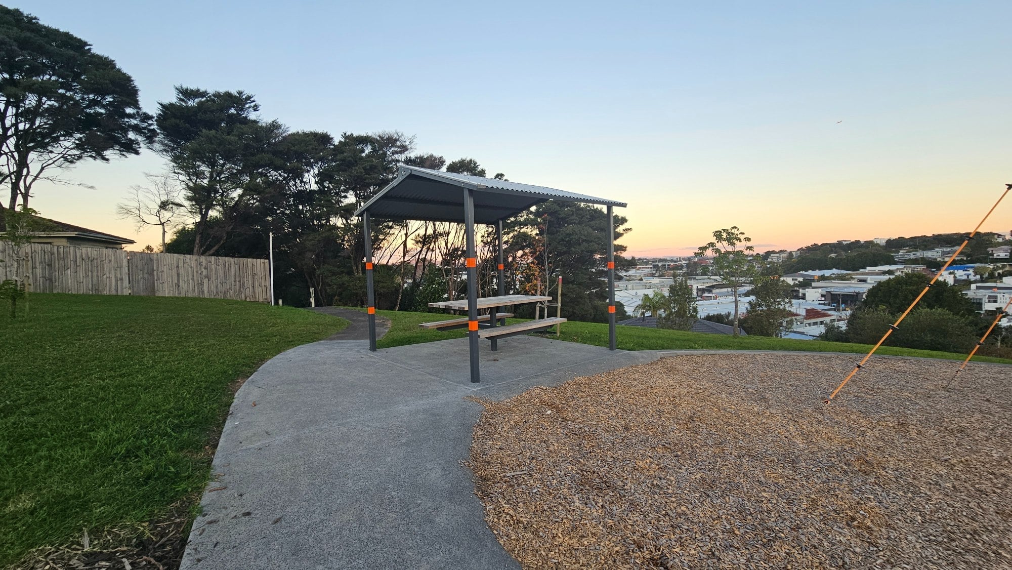 Roofed picnic shelter with the hilltop view right beside you. The orange markings are a thoughtful touch, perhaps there to help prevent people from bumping into it.